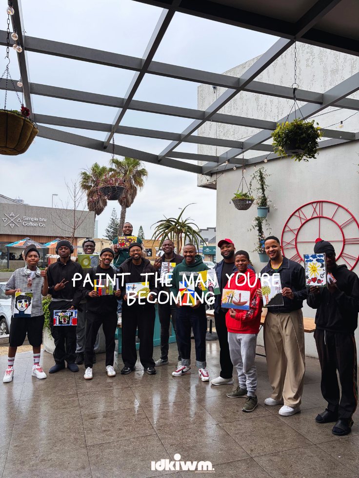 Group of men holding their finished paintings, Paint the Man You're Becoming event